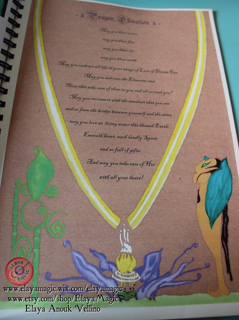 May include: A page from a book with a yellow and white ribbon design. The page has a handwritten message about embracing life and connecting with the elements. The text reads: "A Prayer, Elevation A - May you bless water, may you bless fire, may you bless air, may you bless earth. May you embrace all life in your wings of Love of Dream Fire. May you welcome the Elements and those that take care of them in you and all around you! May you reconnect with the stardust that you are and so form the bridge between yourself and the stars. May you love as living water this blessed Earth. Emerald heart, such kindly Spirit and so full of gifts. And may you take care of Her with all your heart!"