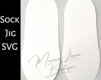 May include: Two white, foot-shaped templates with rounded tops and a textured surface. The text "Sock Jig SVG" is on the left side. The templates have the cursive text "Momma Llama Boutique" at the bottom.