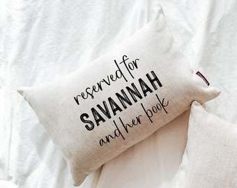 May include: A beige pillow with the text "reserved for SAVANNAH and her book" printed in black.