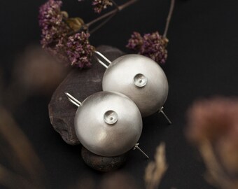 Organic silver circle earrings, shaped into a bowl with fine details, lightweight, with a textured brushed finish ••