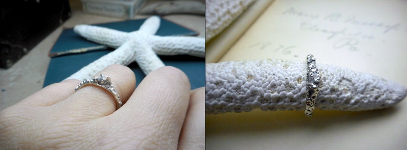 May include: A silver ring with a textured design, featuring small, round stones. The ring is displayed on a white, textured surface.