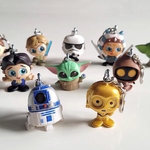 Puede incluir: Una colección de diez llaveros de personajes de Star Wars. Los llaveros están hechos de plástico y presentan personajes como Yoda, R2-D2, C-3PO y Darth Vader.