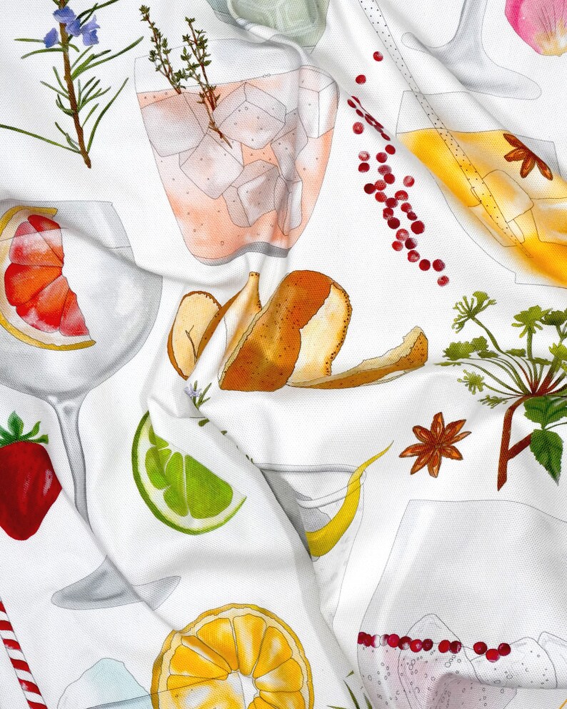 May include: A white tea towel with a colorful pattern of various fruits, herbs, and spices. The pattern includes a grapefruit, lime, orange, star anise, rosemary, thyme, and a peeled pear. There are also several glasses of pink and yellow drinks with ice cubes.