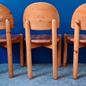 May include: Three wooden chairs with a light brown finish. The chairs have a rounded back and four legs. The chairs are arranged in a row.