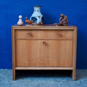Vintage 1950s bedside table in two-tone wood with turned knobs and metal trim