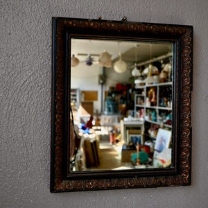 Old rectangular gold and black wall mirror in antique French boho style