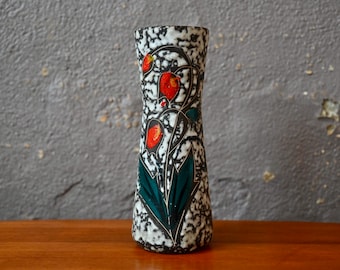 May include: A white ceramic vase with a speckled glaze and a floral design in red, green, and black.