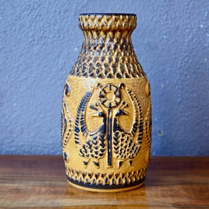 Peut inclure: Un vase en céramique jaune avec un motif géométrique noir et brun et un motif d'oiseau stylisé.