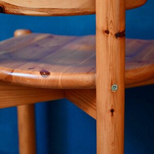 May include: A wooden chair with a natural finish. The chair has a rounded seat and a simple design.