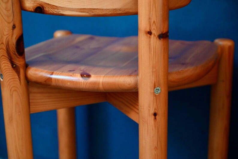 May include: A wooden chair with a natural finish. The chair has a rounded seat and a simple design.