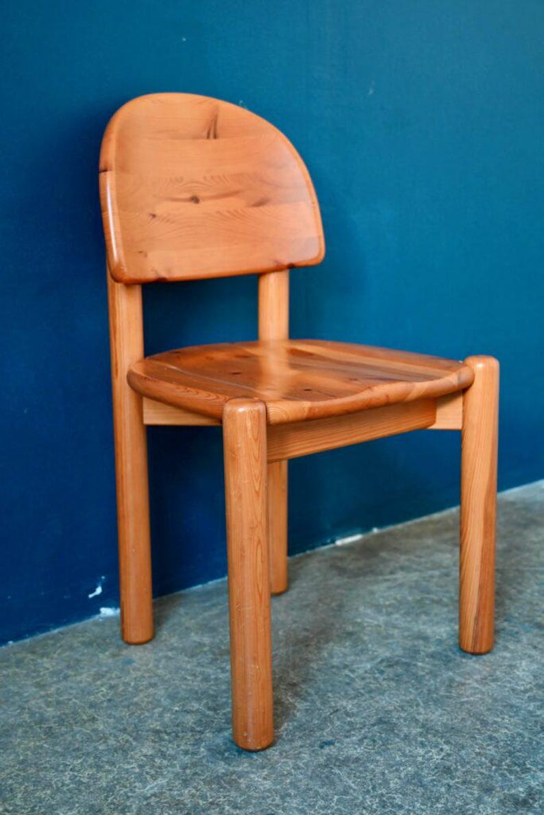 May include: A solid wood chair with a rounded back and four legs. The chair is made of natural wood with a light brown finish.