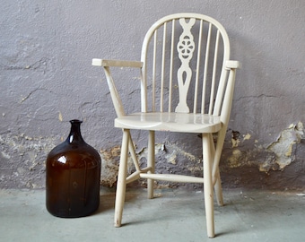 Rustic armchair in patinated wood in boho folk style and chic countryside