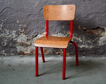 Small children's school chair in wood and red metal with a vintage and industrial look