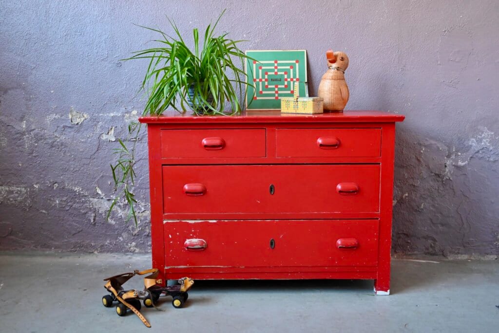Old patinated chest of drawers in red vintage boho and country chic style