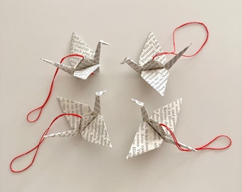 Set of 4 paper cranes, hand-folded decorative pendants made from book pages with red string for hanging, each approx. 6 cm long