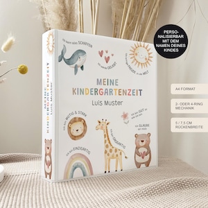 Könnte beinhalten: Ein weißer Ordner mit einem farbenfrohen Design mit Tieren und Text in deutscher Sprache. Der Text lautet "Meine Kindergartenzeit" und "Luis Muster". Der Ordner ist mit dem Namen eines Kindes personalisiert. Er ist im A4-Format und hat einen 2- oder 4-Ring-Mechanismus. Der Rücken ist 14,6 cm breit.
