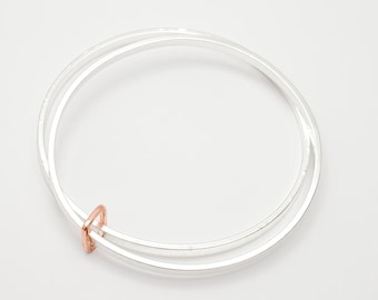 Loja by Fedha - stylish pair of silver bangles, hammered, polished, with yellow gold link, stylish and understated