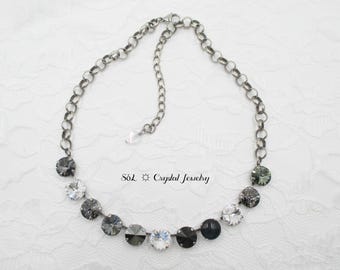 Puede incluir: Un collar de cadena plateada con una fila de piedras de cristal negras y transparentes. El collar está sobre un fondo blanco. Söl Crystal Jewelry.