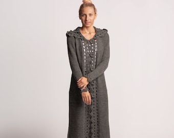Könnte beinhalten: Ein langer grauer Cardigan mit Häkelrand und Kapuze. Der Cardigan hat einen Knopfverschluss und ist aus weichem, gestricktem Stoff.