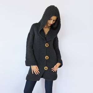May include: A long, charcoal gray knitted cardigan with a large hood and wooden button closures.