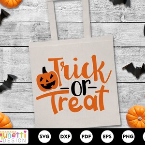 Puede incluir: Una bolsa de tela blanca con el texto "Trick or Treat" en letras naranja y negras. El texto est&aacute; en una fuente de letra manuscrita. Hay una peque&ntilde;a calabaza naranja con una cara negra en la esquina superior izquierda de la bolsa.