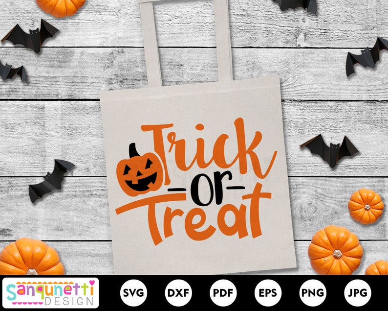 Puede incluir: Una bolsa de tela blanca con el texto "Trick or Treat" en letras naranja y negras. El texto est&aacute; en una fuente de letra manuscrita. Hay una peque&ntilde;a calabaza naranja con una cara negra en la esquina superior izquierda de la bolsa.