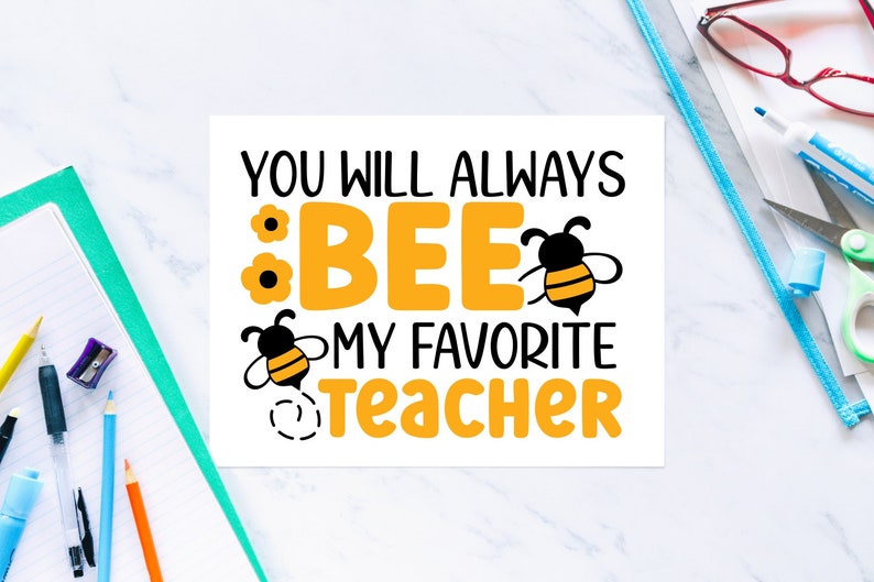 May include: A white square print with the text "YOU WILL ALWAYS BEE MY FAVORITE TEACHER" in black and orange. The word "BEE" is in large orange letters with bee and flower graphics. Stationery items surround the print.