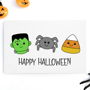 Pu&ograve; includere: Un biglietto bianco con un Frankenstein verde, un ragno grigio e un mais caramellato arancione e bianco con facce felici. Il testo "HAPPY HALLOWEEN" &egrave; sotto i personaggi.