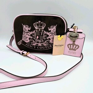 May include: A black crossbody bag with a pink strap and trim, featuring a pink crest design with the words "Juicy Couture." A matching pink cardholder and tag are also included.