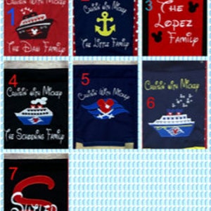 May include: A collection of seven personalized flags with various designs and text. The flags feature cruise ship and anchor motifs, with names like "The Dow Family" and "The Lopez Family" embroidered on them. The flags are in red, blue, and black.
