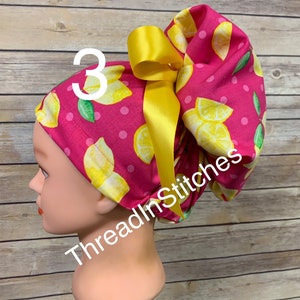 May include: Pink and yellow surgical scrub hat with a lemon print and a yellow bow. The hat is on a mannequin head. The text "ThreadInStitches" is on the hat. The number "3" is on the hat.