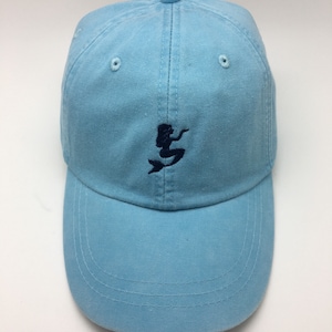 Puede incluir: Una gorra de b&eacute;isbol azul claro con un dise&ntilde;o de sirena bordado en azul oscuro.