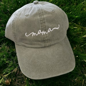 May include: A green baseball cap with white embroidery that says "mama".
