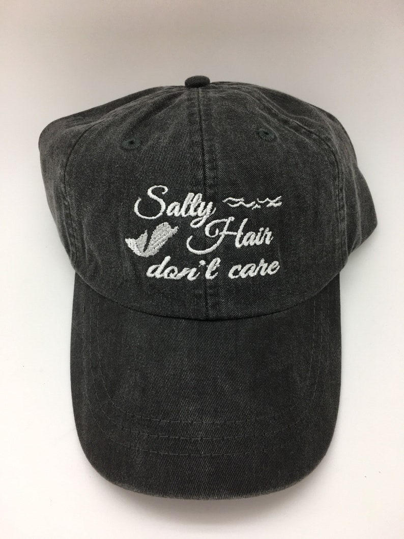 May include: A black baseball cap with white embroidery that reads "Salty Hair don't care" with a wavy line and a small seagull graphic.