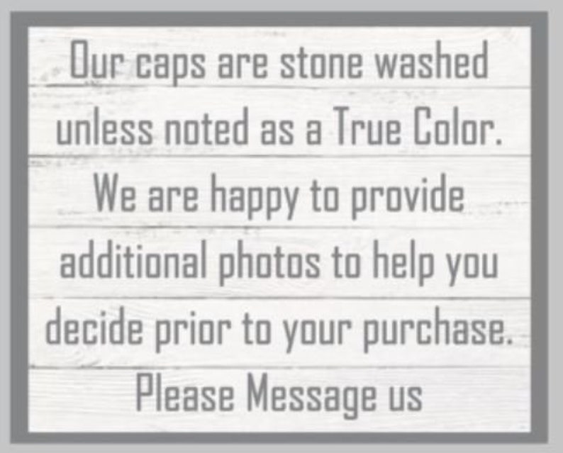 May include: A rectangular sign with a gray border and a white, wood-grain background. The text reads: "Our caps are stone washed unless noted as a True Color. We are happy to provide additional photos to help you decide prior to your purchase. Please Message us."