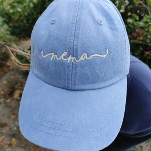 May include: A light blue baseball cap with the word "mama" embroidered in white on the front.