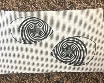 May include: Two black and white spiral eye illusions on a white background with a fine grid pattern.