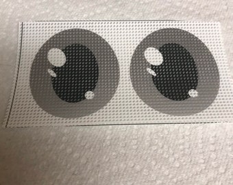 May include: Two grey and black cartoon eyes with white pupils on a white canvas background.