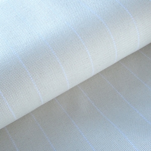 May include: Close-up of a light beige fabric with a subtle grid pattern of thin, light blue lines. The fabric is rolled, revealing its texture and the interplay of light and shadow. The material appears to be tightly woven.
