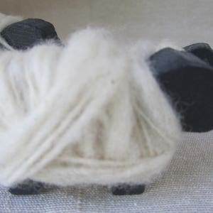 close-up of the hand-spun wool wrapped around wooden sheep