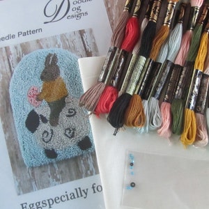 May include: A punch needle pattern kit with a bunny design, embroidery floss in various colors, and a piece of fabric. The kit includes a pattern, floss, and other supplies for a craft project. The text "Eggspecially for" is visible.