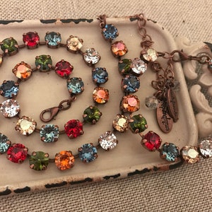 May include: A multi-colored crystal necklace with a copper chain and a small tag that says "emilybeads handmade".