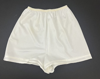 May include: White nylon slip shorts with a satin trim. The shorts have a wide elastic waistband.