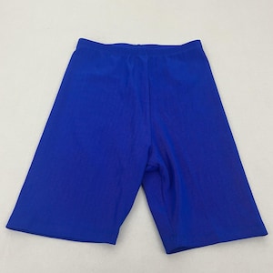 May include: A pair of royal blue biker shorts. The shorts are made of a smooth, stretchy fabric and have a high waist. The shorts are designed to be worn for exercise or casual wear.