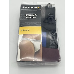 May include: A four-pack of Joe Boxer string bikini underwear in a clear plastic package. The package includes underwear in various colors, including black, gray, blue, and burgundy. The packaging features the Joe Boxer logo and the words "String Bikini."