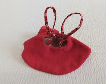 May include: Red fabric doll dress with white and black patterned straps.