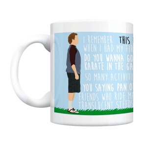 May include: White ceramic mug with a blue and green illustration of a cartoon character. The mug features text that reads "I remember this when I had my first karate class. Do you wanna go karate in the garage? So many activities. You saying pan or friends who ride my translucent steeds?"