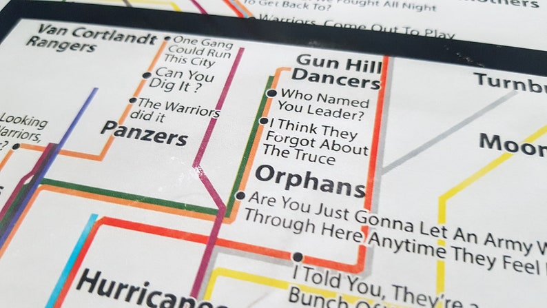 May include: A subway map with lines and stops labeled with names and phrases. The map is printed on white paper with red, orange, yellow, green, blue, and purple lines. The names of the stops include "Van Cortlandt Rangers", "Gun Hill Dancers", "Orphans", "Panzers", "The Warriors", "Can You Dig It?", "One Gang Could Run This City", "Who Named You Leader?", "I Think They Forgot About The Truce", "Are You Just Gonna Let An Army Through Here Anytime They Feel", "I Told You, They're Bunch", "Turnbull", "Moore", and "Looking Warriors".