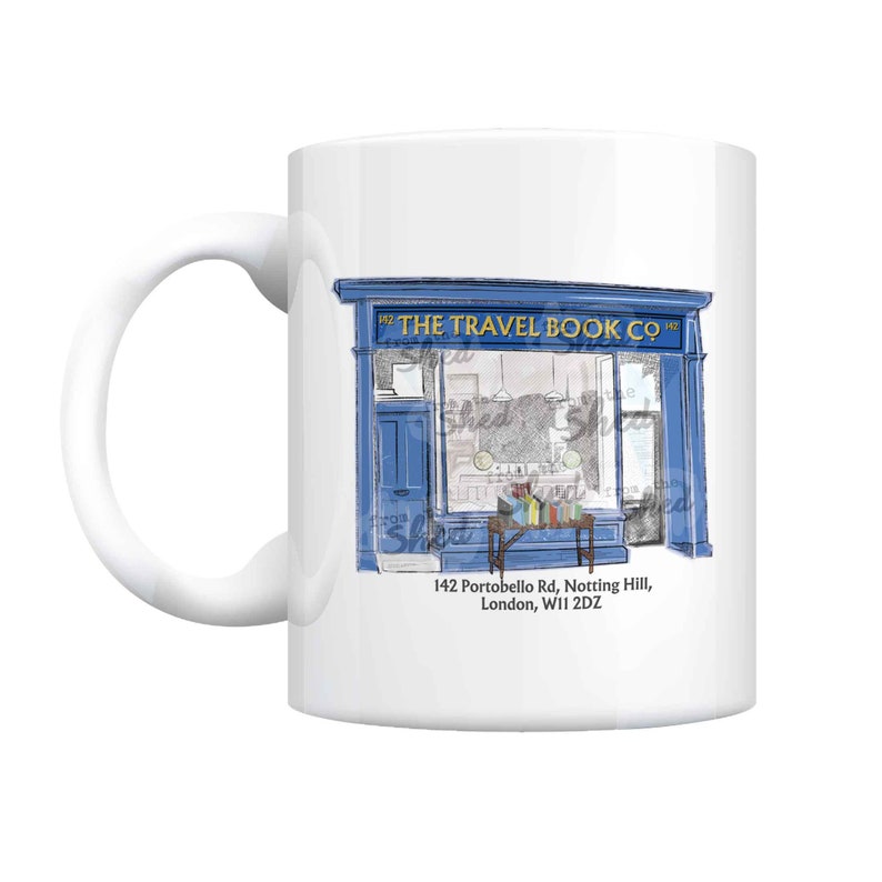May include: White ceramic mug featuring a blue illustration of "The Travel Book Co" storefront. The shop's facade is detailed with a blue door, windows, and signage. The address "142 Portobello Rd, Notting Hill, London, W11 2DZ" is printed below the shop.