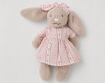 May include: A plush bunny toy with long, floppy ears and a pink gingham dress. The bunny has a matching bow on its head and a stitched face. The dress features vertical floral accents.